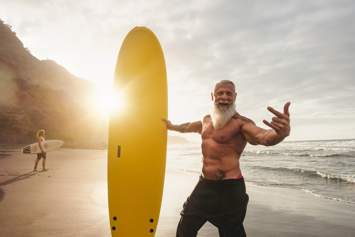 Happy Fit Senior Surfing at Sunset Time 